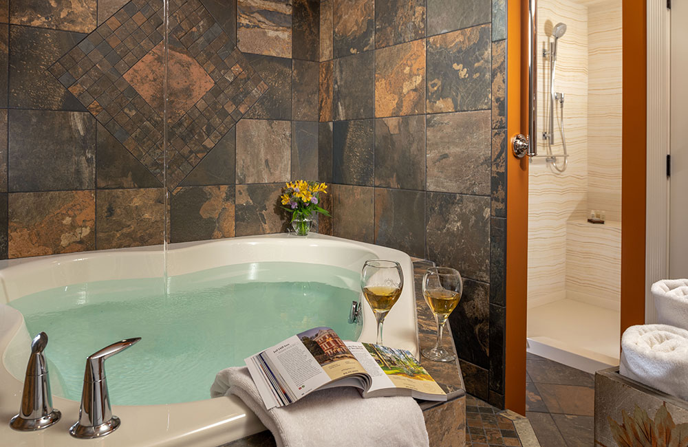 An oversized tub and glass of wine in one of the bathrooms of our Bed and Breakfast in Galena, IL - the best place for a romantic Galena, IL Getaway