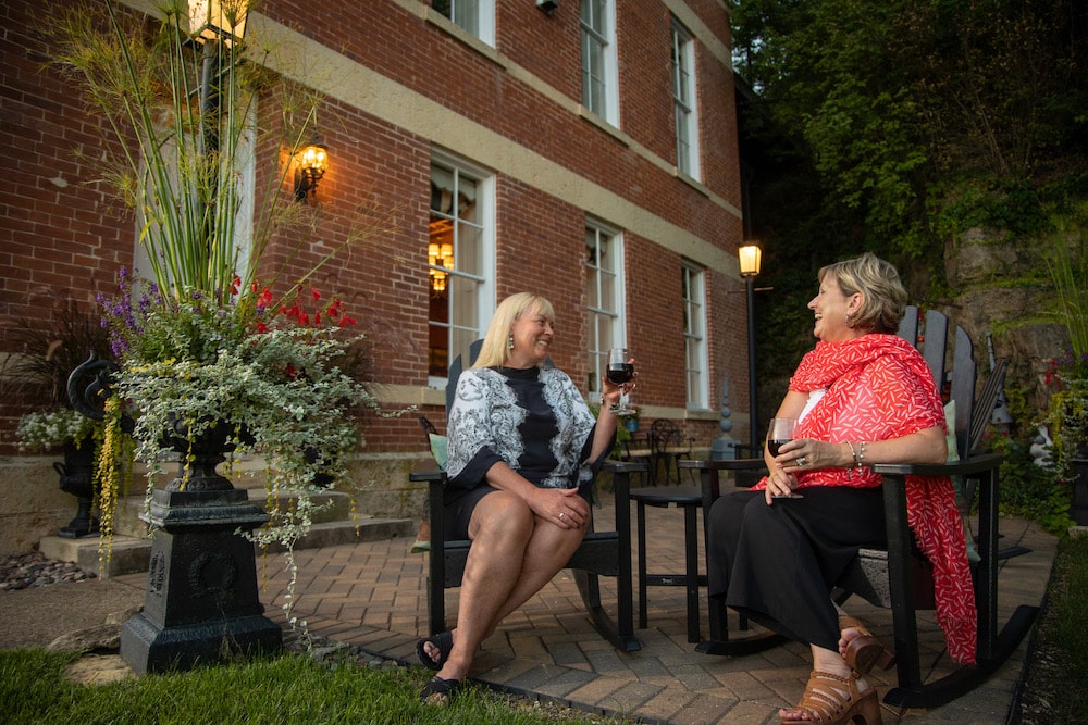 two women enjoying drinks on the patio at Jail Hill Inn, the best place to stay in Downtown Galena