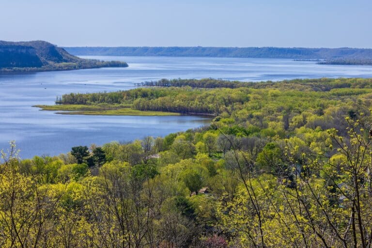 The Mississippi River Valley, a landscape of water and green trees, that you can experience close up with a Mississippi river boat cruise at Chestnut Mountain Resort.