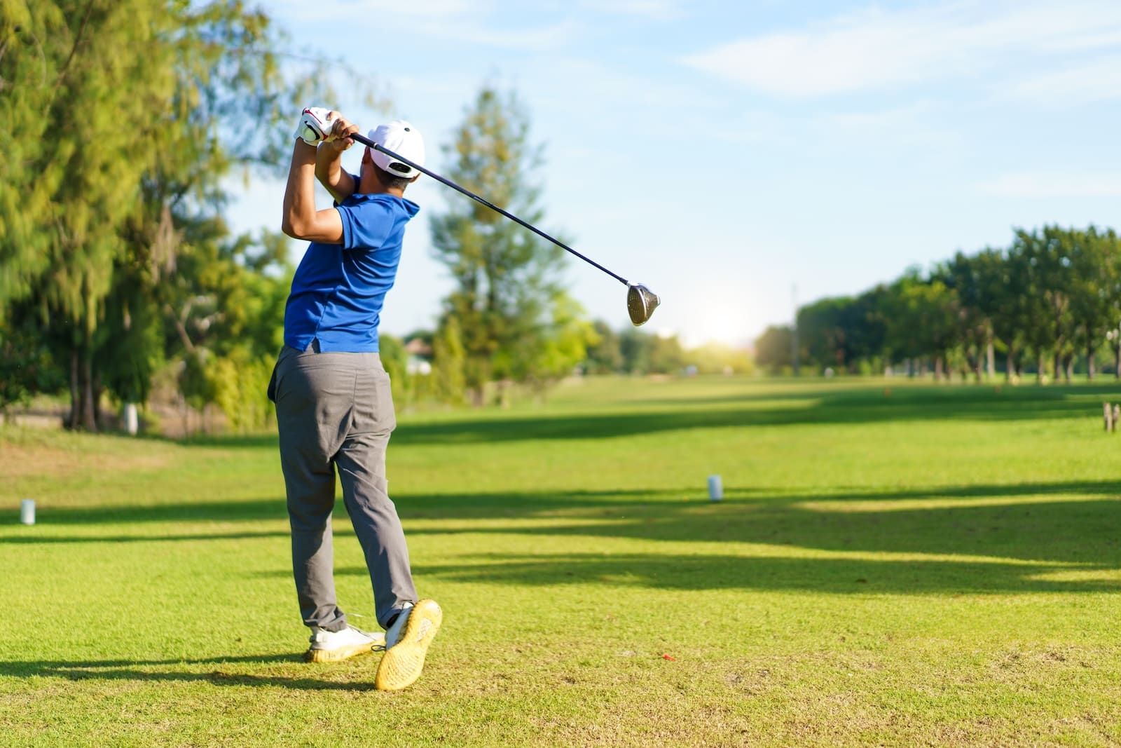 A man swings his golf club on a field of green at one of the best Galena golf courses.