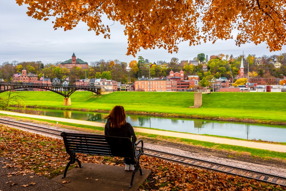 Woman sitting on a bench in fall at Grant Park in Galena - the best fall foliage near our Galena Bed and Breakfast