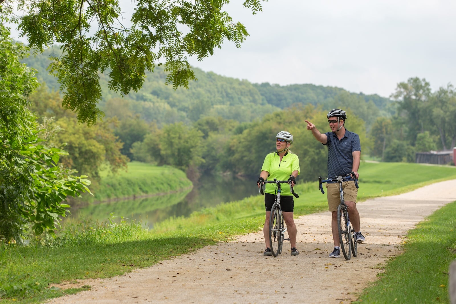 two people riding bikes along the Galena River Trail, one of our favorite things to do in Galena