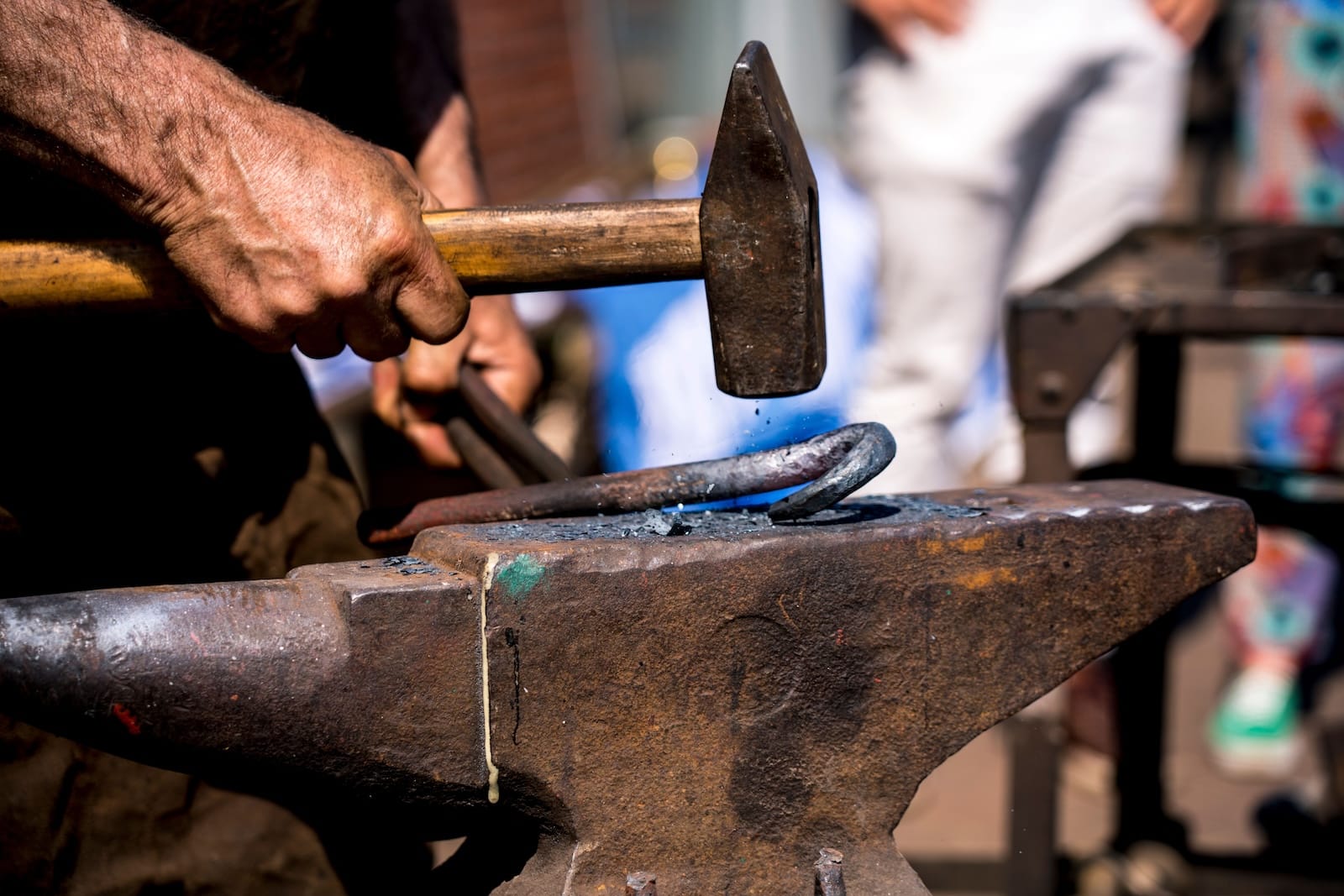 Discover the Historic Old Blacksmith Shop in Galena 1 A blacksmith hammering hot metal on an anvil, showcasing traditional craftsmanship at the Old Blacksmith Shop in Galena, IL.