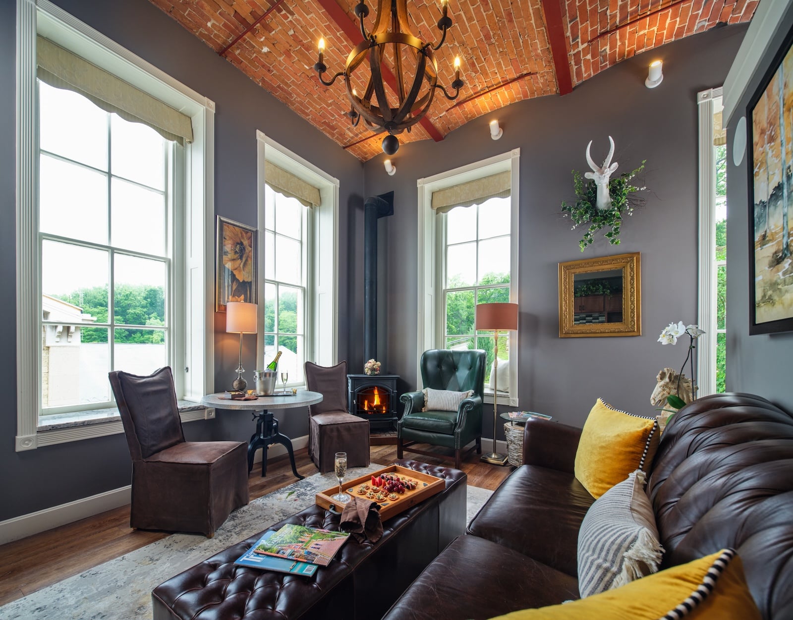 A living area with charcuterie on the coffee table and large windows at a Galena IL bed and breakfast.